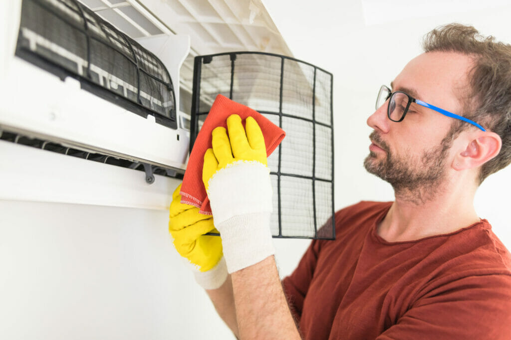 An expert technician tuning up an air conditioner for optimal performance, using professional tools and techniques