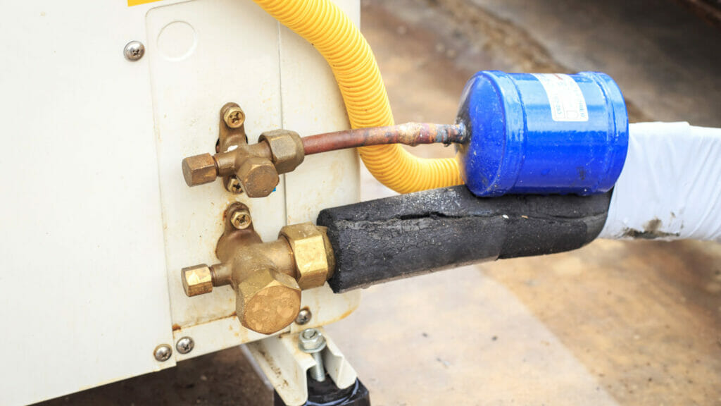 Close-up of an AC condensate drain line, focusing on the tubing and connections that enable efficient drainage, indicative of the discussion on proper installation and routing of the line.