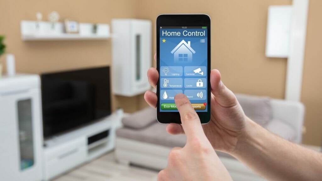 Individual adjusting home's temperature and moisture settings using a smart home control app on a mobile phone.