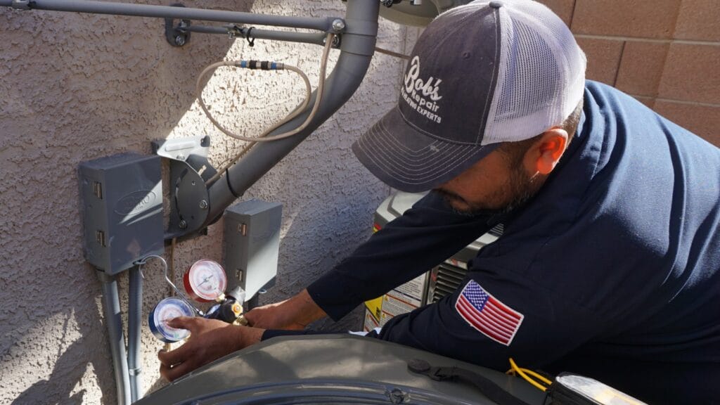 Bob’s Repair technician repairs an AC unit, using diagnostic tools, in a residential setting