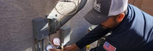 A Bob’s Repair technician using refrigerant gauges on an outdoor air conditioning unit