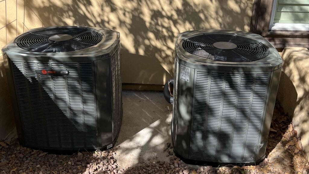 Two heat pump units installed side by side outside a building.