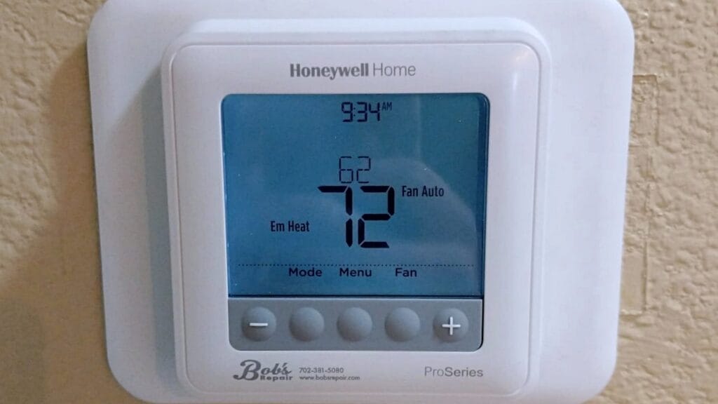 Digital Honeywell Home thermostat displaying 72°F with the fan set to auto mode and emergency heat mode active