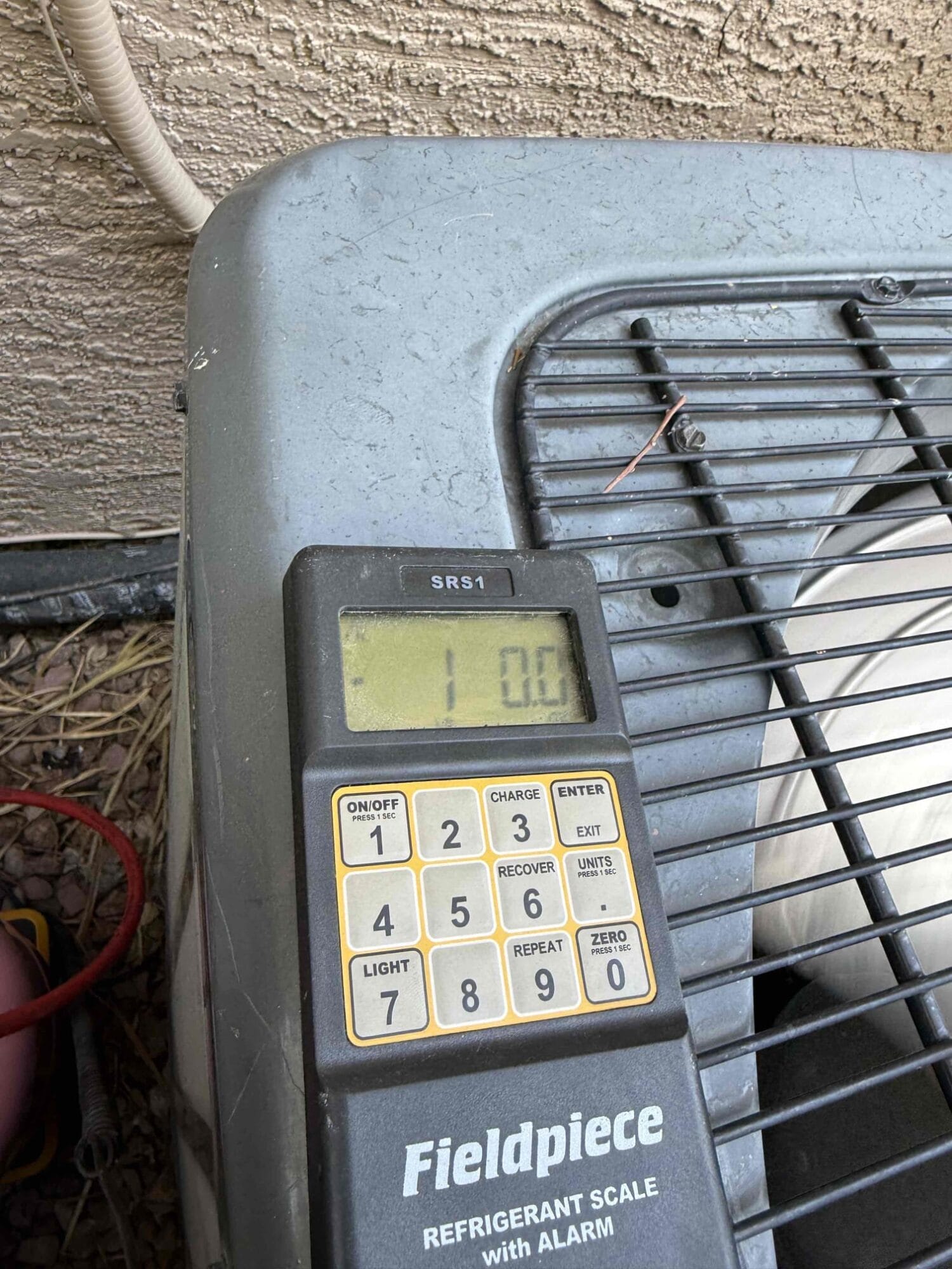Fieldpiece refrigerant scale showing 1.00 pounds charged into the system.