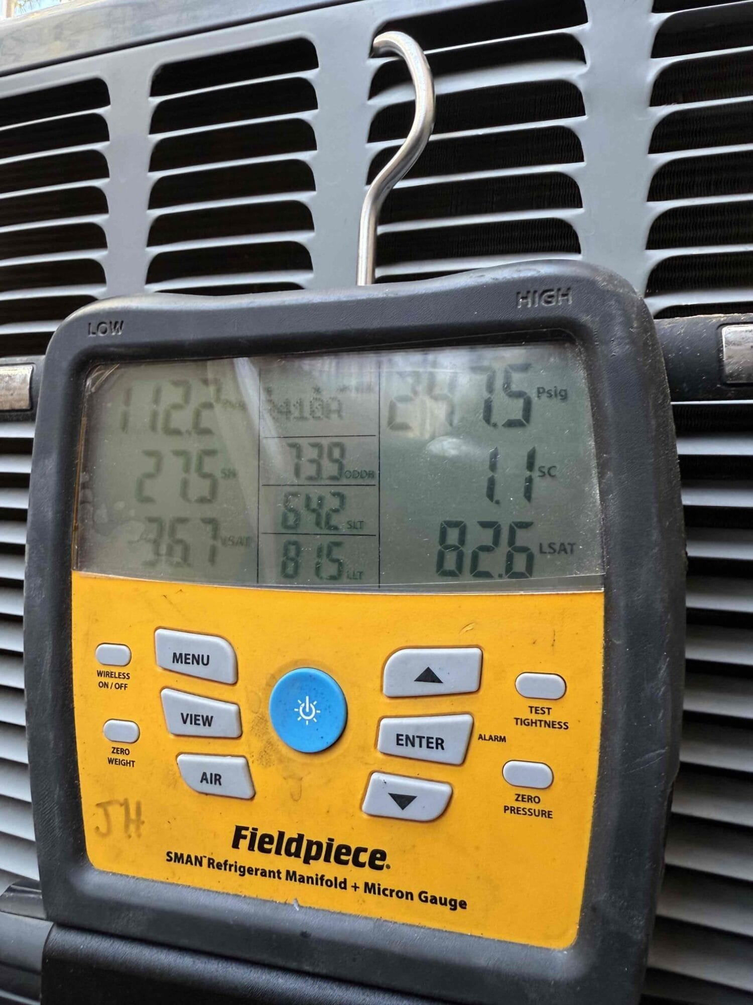 Fieldpiece manifold gauges displaying refrigerant pressures during diagnostic.
