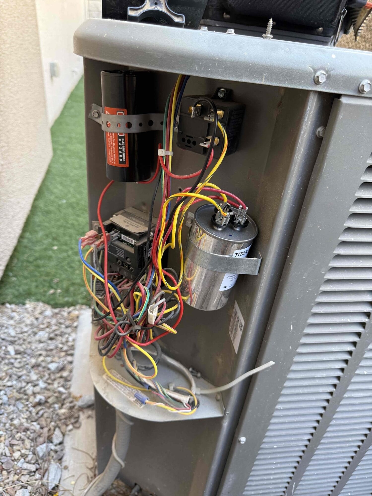 Completed installation showing newly replaced capacitors and tidied wiring layout inside the HVAC unit.