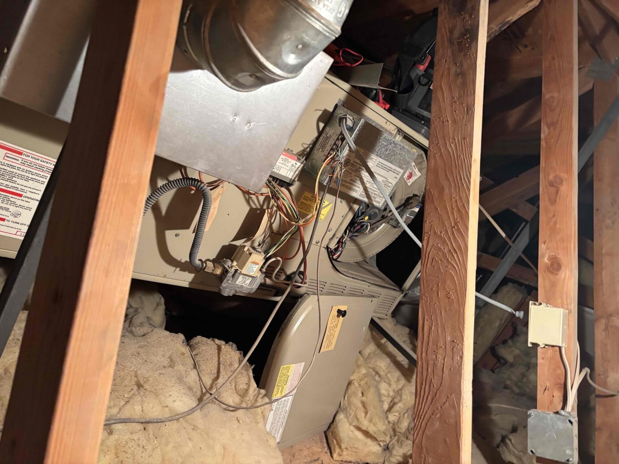 View of attic furnace showing wiring, control board, and motor area where buzzing was detected.
