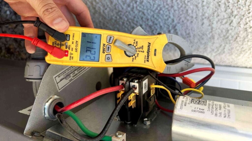 Multimeter showing 11.22 amps on an AC unit’s electrical circuit.