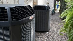 Two outdoor AC condenser units, including a Trane system, installed at the side of a Las Vegas residential home — typical setup for snowbird seasonal AC startup