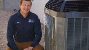 A Bob's Repair technician named Jose kneels beside an outdoor air conditioning unit, the kind of visit renters call for when their ac is not working in a Las Vegas apartment.