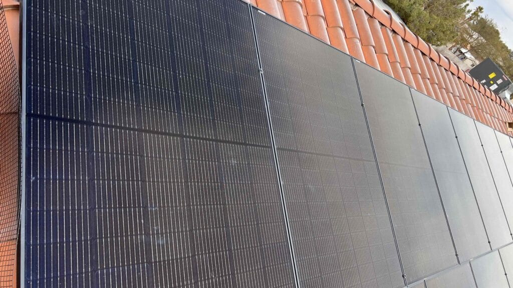 A close-up view of newly mounted solar panels on a tile roof illustrates the rooftop wiring and mounting work planned during new construction HVAC in the Las Vegas Valley, including Summerlin and Henderson.