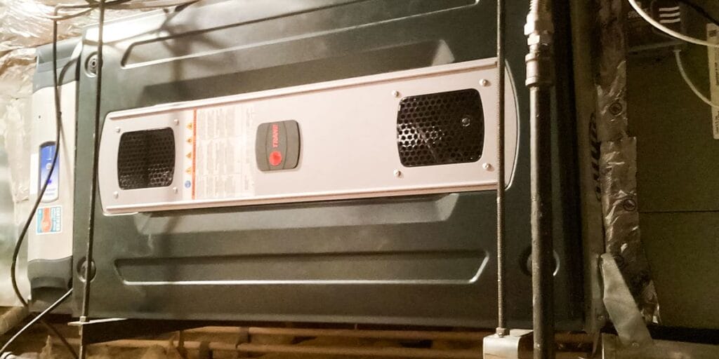 A Trane HVAC unit installed in a crawl space, representing a key component for professional AC repair and heater repair services.